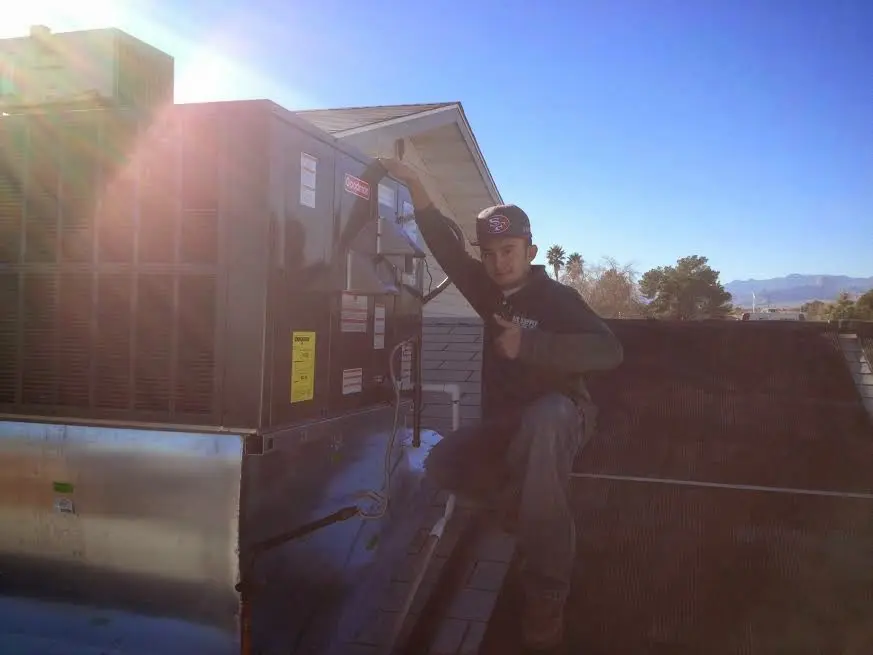 HVAC technician performing Boiler Repair on a rooftop unit in Los Osos